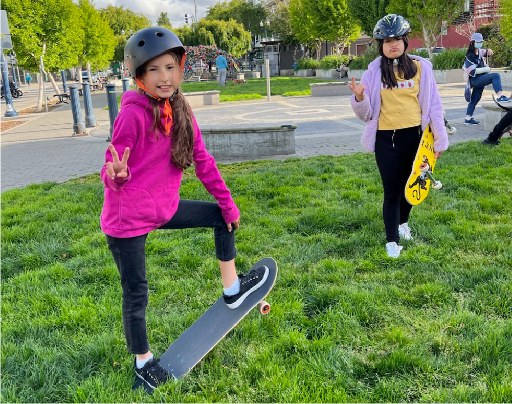 COS girls pose in a park with their skateboards
