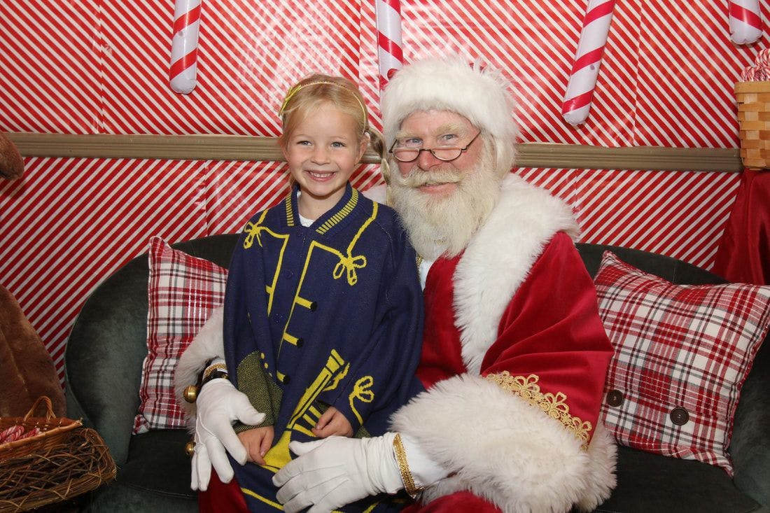 A girl sits on Santa's lap at the annual SantaFest party