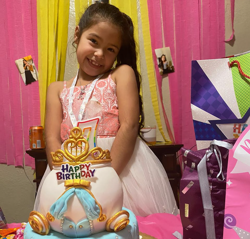 A COS girl celebrates her birthday with a cake and princess themed party